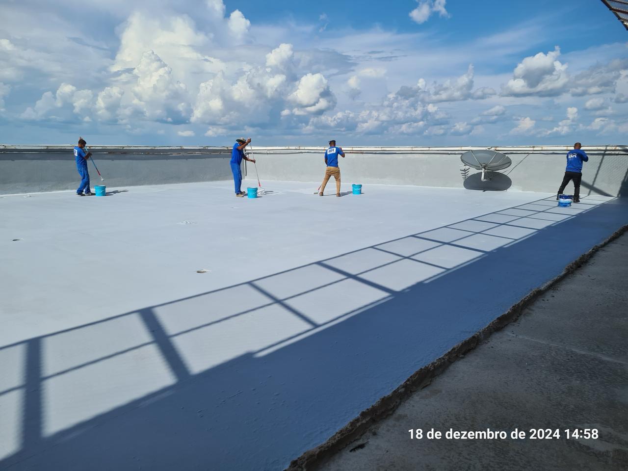 Equipe aplicando impermeabilização em laje plana